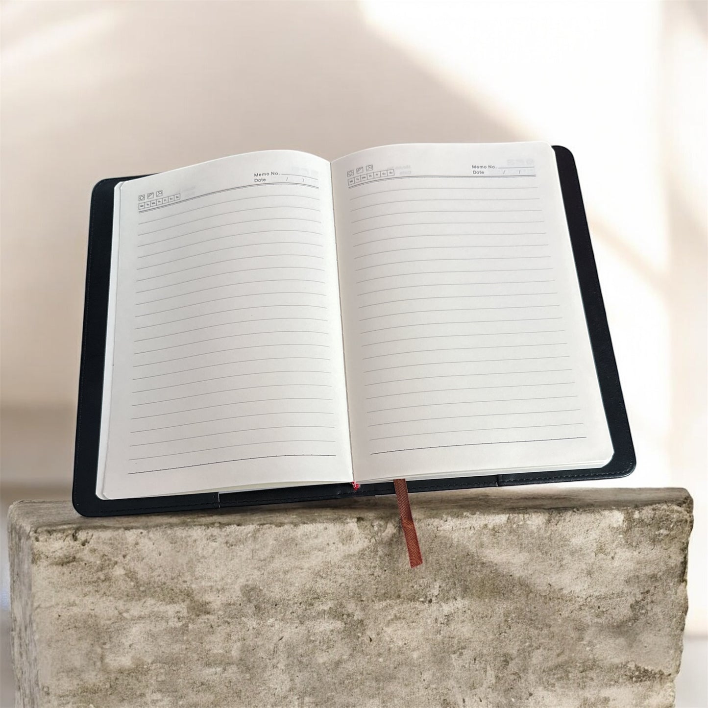 Open notebook with lined pages on a concrete surface